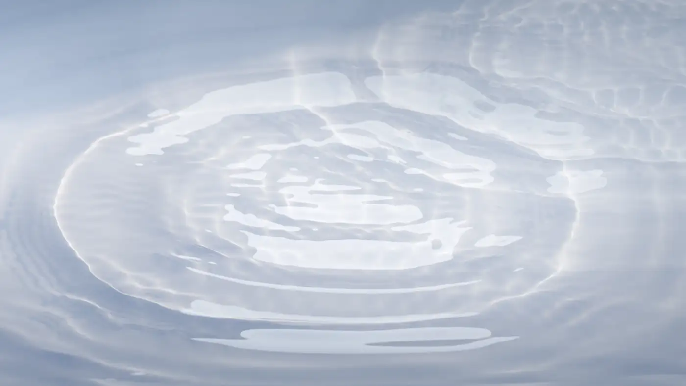 Soft concentric ripples merging into one still surface, boundaries fading