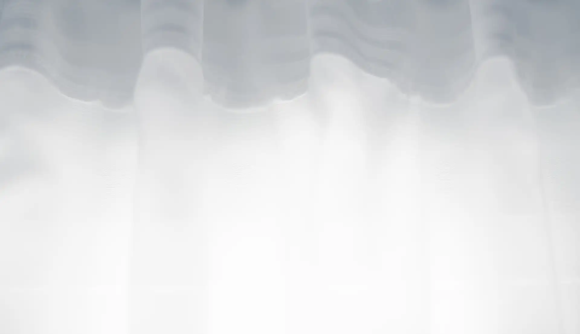 A sheer white veil dissolving softly into light, edges hard to locate