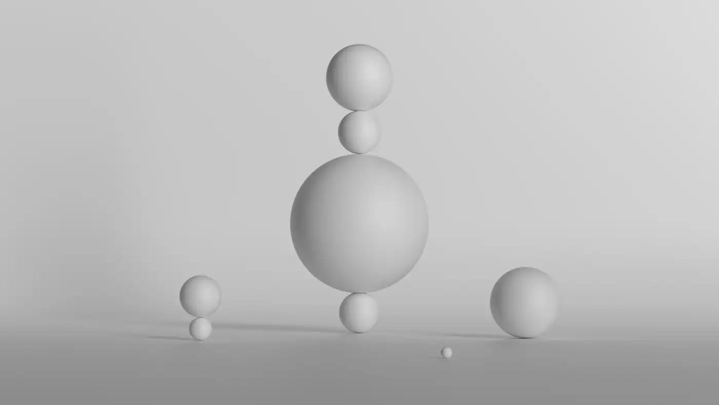 Spheres of decreasing size balanced together on a pale ground