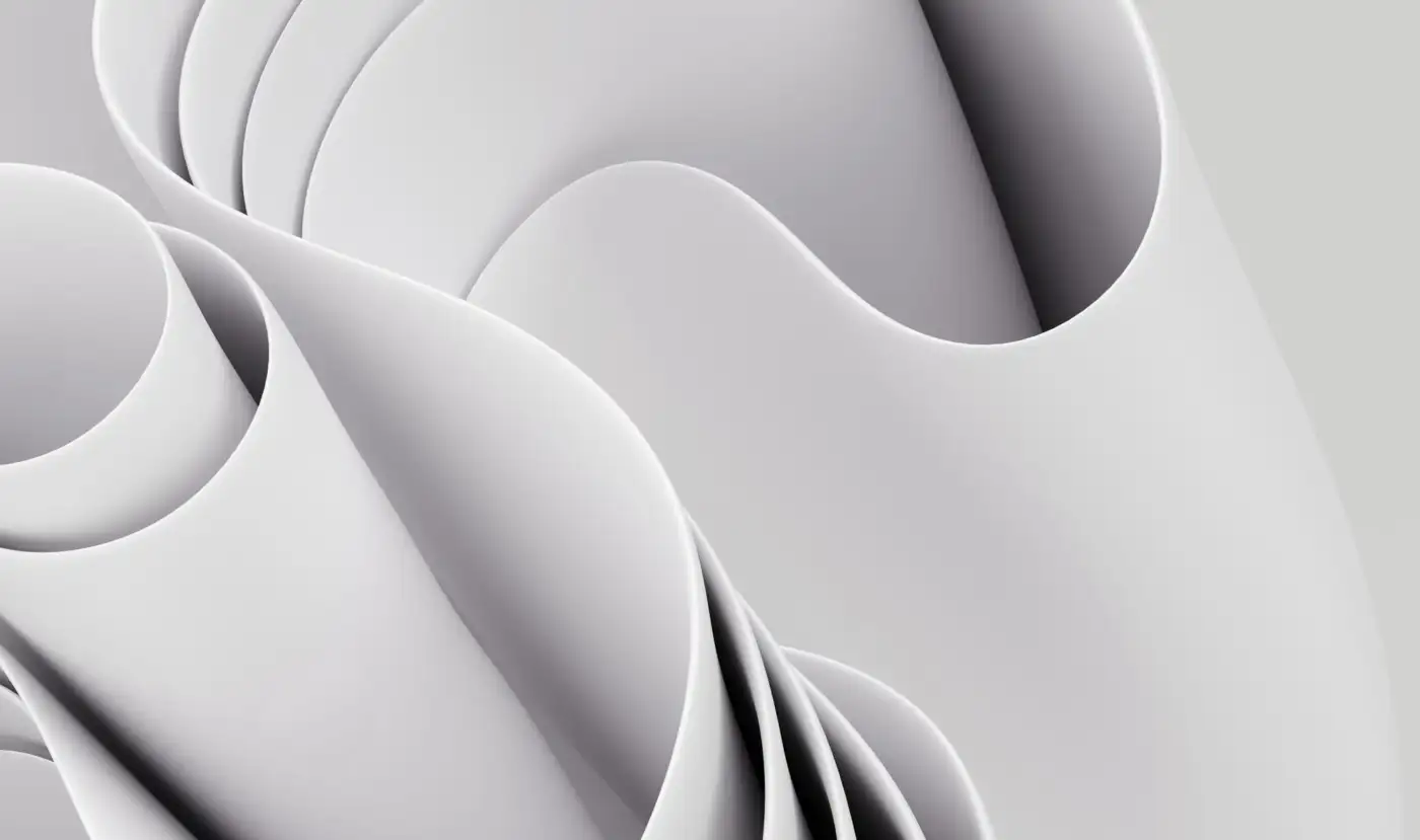 Smooth white sheets curling over one another in soft light