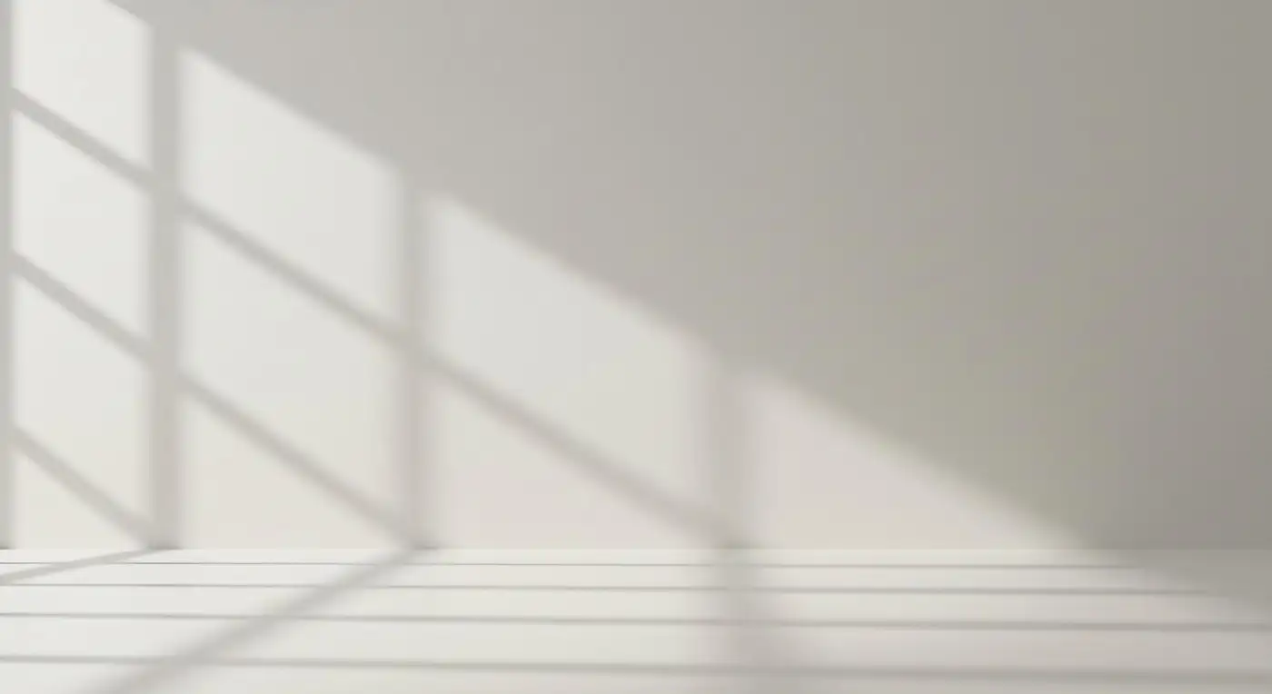 Soft window light falling in slanted bands across a plain wall