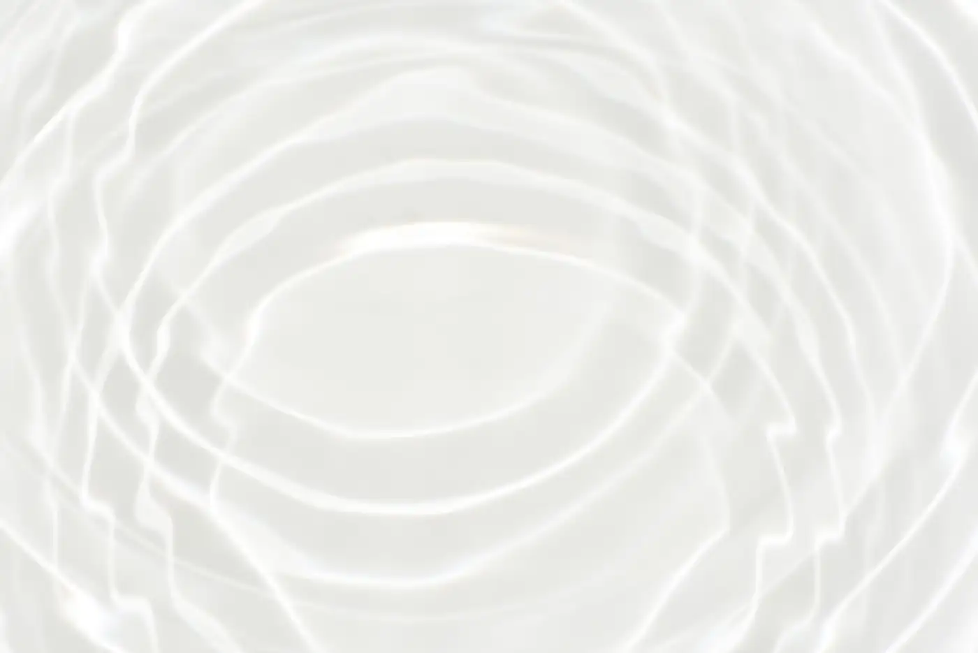 Overlapping ripples spreading across a still, pale surface