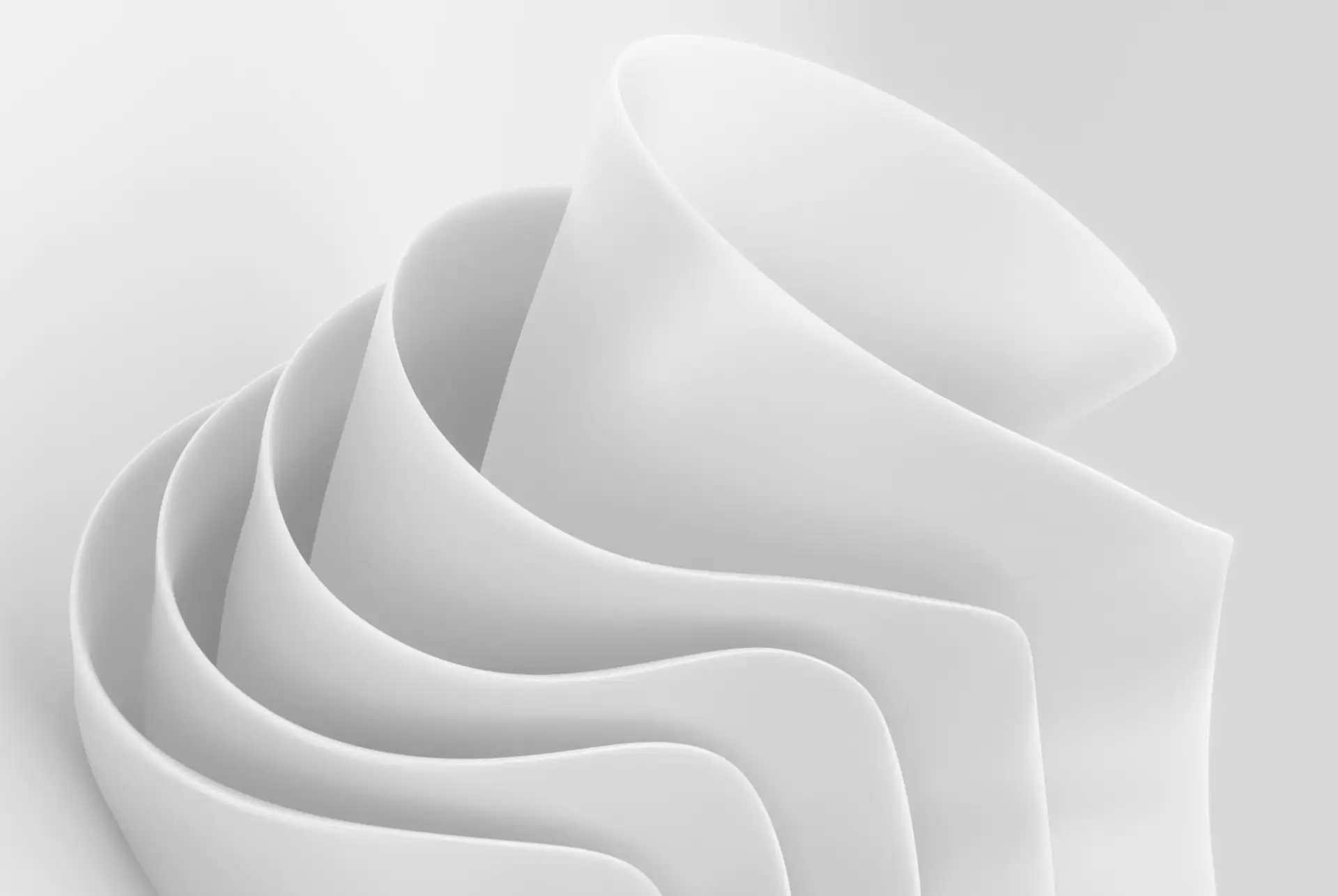 Nested white curves folding into one another in soft light